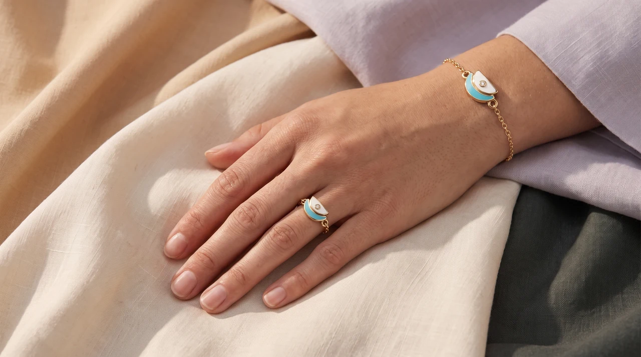 A hand wearing the Amara Ring and the Amara Bracelet in yellow gold
